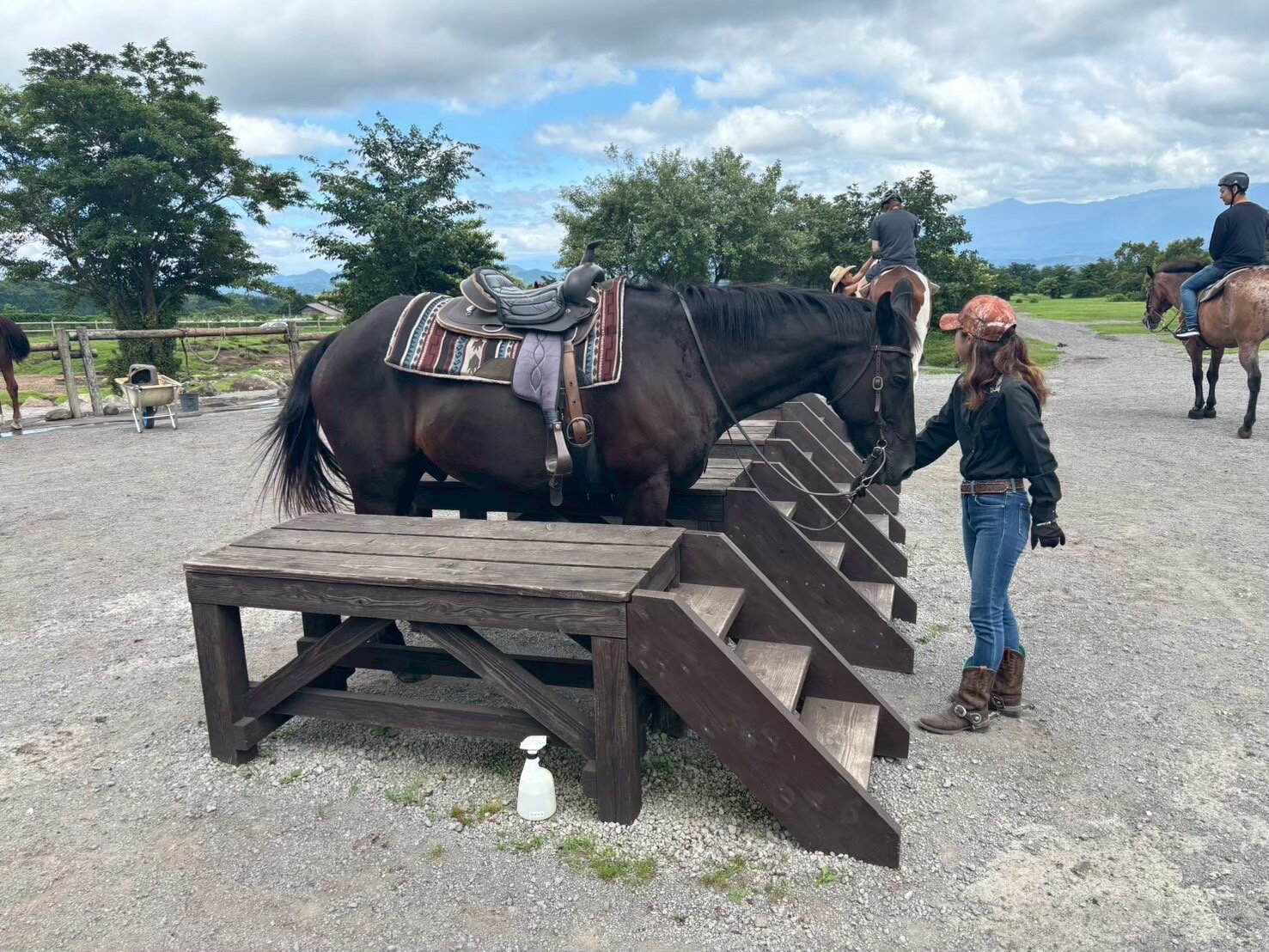 Leading a horse from the mounting platform toward the training yard at Kokopelli Western Riding