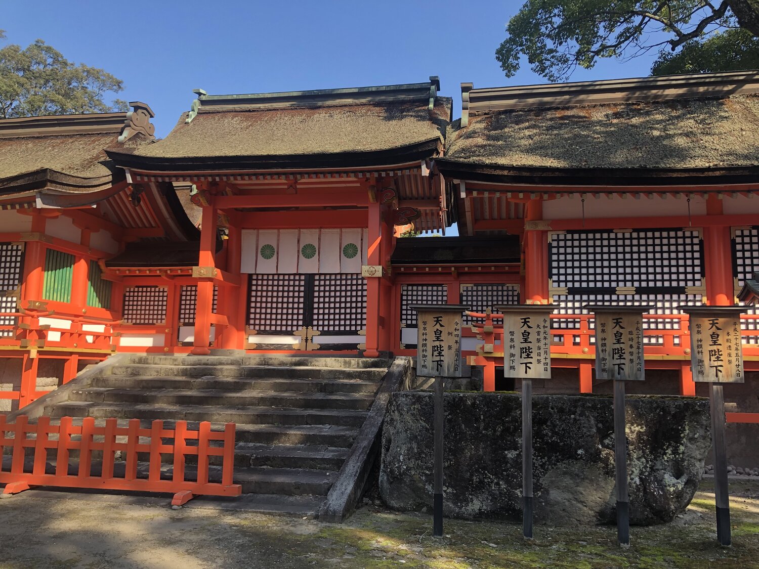 The vermillion honden buildings of Usa Jingu with thatched roofs, viewed from the courtyard